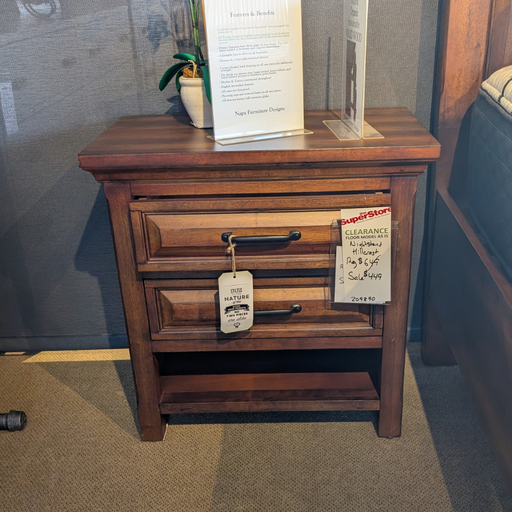 Wooden nightstand with a tag on a carpeted floor