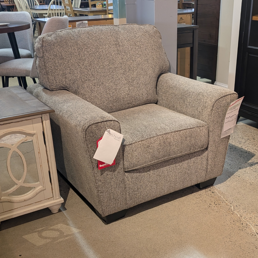 Brown armchair with tags in a showroom setting