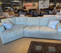 Sectional sofa in a furniture store with 'SuperStore' branding in the background.